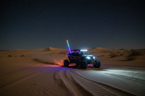 UTV en desierto con whip encendida de noche